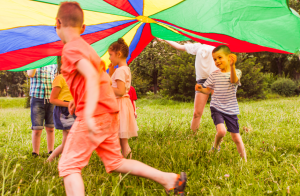 A group of children playing underneath a parachute