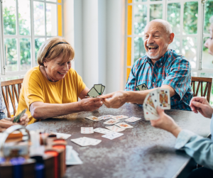 A group of elderly people playing cards and laughing