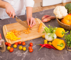 A person chopping vegetables on a cutting board