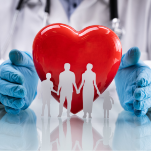 A stock photo of a gloved surgeon's hands with a paper doll family in front of a red heart. Intended to accompany the Medicare Educational Seminar.