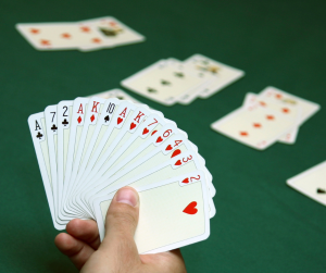 A stock image of a person holding a fanned out hand of cards