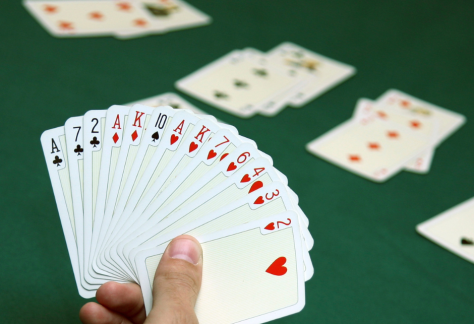 A stock image of a person holding a fanned out hand of cards.
