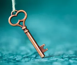 A key on a string against a turquoise backdrop