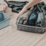 A person organizing clothing into different bins